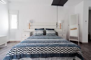 a bedroom with a large bed in a white room at Apartamento Loft Sopranis in Cádiz