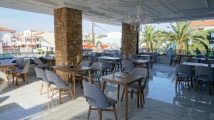 un ristorante con tavoli, sedie e lampadario a braccio di Agnes Deluxe Hotel a Pefkohori