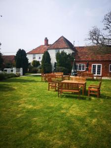 a group of wooden tables and benches in a yard at The White Hart Inn in Newbury