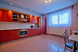 a kitchen with red cabinets and a window at NA BYSTRYM in Zakopane