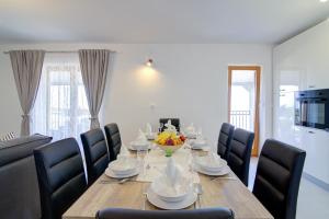einen Esstisch mit Stühlen und eine Obstschale darauf in der Unterkunft Josipa & Jelena Apartment in Senj