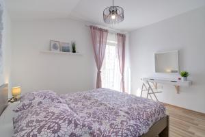 Schlafzimmer mit einem Bett, einem Schreibtisch und einem Fenster in der Unterkunft Josipa & Jelena Apartment in Senj