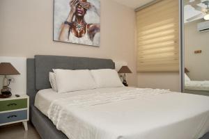 1 dormitorio con 1 cama blanca y una pintura en la pared en נוף לים האדום - sea view eilat, en Eilat
