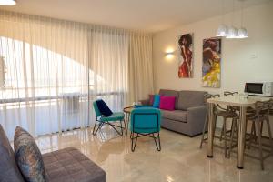 sala de estar con sofá, mesa y sillas en נוף לים האדום - sea view eilat, en Eilat