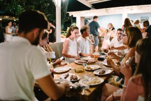 een groep mensen die rond een tafel eten bij Ampavris Family Apartments in Kos-stad