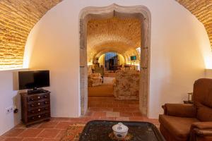 a living room with an archway with a couch and a tv at Quinta da Foz in Foz do Arelho