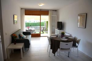 a living room with a table and chairs and a living room at Apartamentos Laura Mar in Palamós