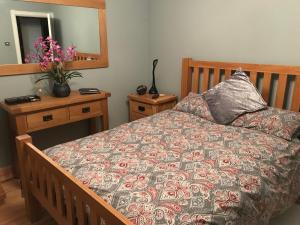 1 dormitorio con cama con almohada y espejo en Villacai, en Nailsea