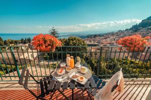 un tavolo con cibo e bevande in cima a un balcone di B&B Teatro Greco 39 a Taormina