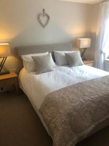 een slaapkamer met een groot bed met witte lakens en kussens bij No 1 Fairbank in Kirkby Lonsdale