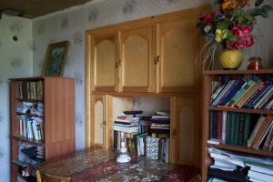 a room with a table and book shelves with books at Ancient Lahij Guest House in Lahıc