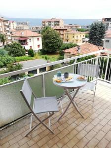 d'une table et de deux chaises sur un balcon. dans l'établissement Appartamento Ivrea Centro - Sito UNESCO, à Ivrea