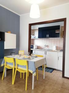 une cuisine et une salle à manger avec une table et des chaises jaunes dans l'établissement Appartamento Ivrea Centro - Sito UNESCO, à Ivrea