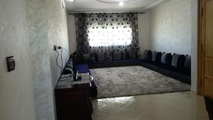 uma sala de estar com um sofá e uma janela em LES CHRIFIs ETAPE AÉROPORT NAVETTE AÉROPORT GRATUITE em Fez