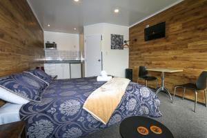 a bedroom with a bed and a table with chairs at New Plymouth TOP 10 Holiday Park in New Plymouth