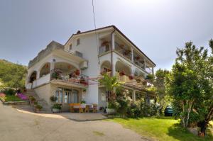 a large white building with flowers on the balconies at Josipa & Jelena Apartment in Senj