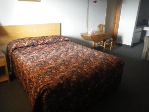 a bedroom with a bed and a dresser at Alcan Motor Inn in Haines Junction