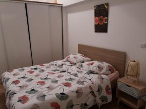 um quarto com uma cama com uma colcha em Maison 2 chambres, cosy, proche Métro em Toulouse