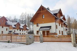 a house with a wooden fence in front of it at Szarlotka in Szczawnica