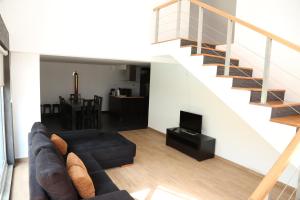 ein Wohnzimmer mit einer Couch und einer Treppe in der Unterkunft Quinta do Moinho in Castelo de Paiva