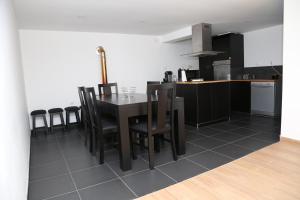 eine Küche mit einem schwarzen Tisch und Stühlen in der Unterkunft Quinta do Moinho in Castelo de Paiva