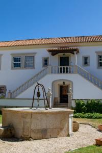 une maison avec une fontaine devant elle dans l'établissement Quinta da Foz, à Foz do Arelho