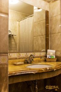 a bathroom counter with a sink and a mirror at Apart Hotel El Doral in Lima