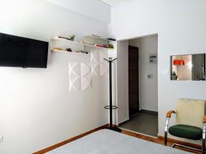 ein Wohnzimmer mit weißen Wänden und einem grünen Stuhl in der Unterkunft Athens Pangrati modern apt 10min to metro in Athen