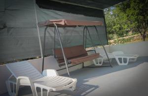 - une balançoire avec 2 chaises et un banc dans l'établissement Villa Baras garden - house with pool, à Mirce