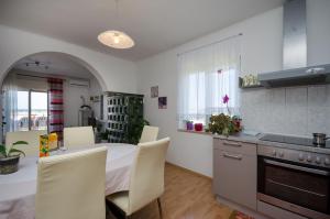 a kitchen with a table and chairs in a kitchen at Apartment Milja in Banjol +21 photos