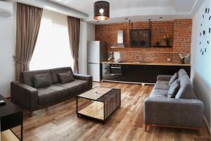 uma sala de estar com dois sofás e uma cozinha em Aquamarine Apartments em Saranda