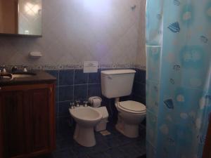 a bathroom with a toilet and a sink at Cabañas El Refugio de Juan in Mina Clavero +36 photos