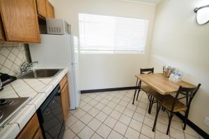 a small kitchen with a table and a refrigerator at Los Gatos Lodge in Los Gatos