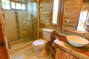 a bathroom with a toilet and a shower and a sink at Hotel Oasis & Surf Camp in Santa Catalina