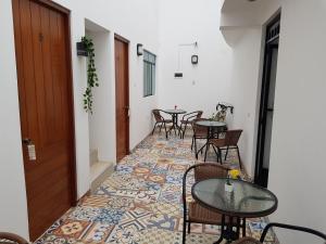 un pasillo con mesas y sillas y un piso en Casa Fina Hospedaje, en Huarmey
