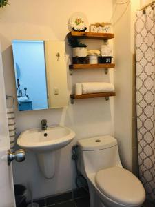 La salle de bains est pourvue de toilettes blanches et d'un lavabo. dans l'établissement New York Suite 1 at Avida Towers Aspira, à Cagayán de Oro