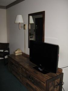 a television on a dresser in a room with a mirror at Branding Iron Motel in Chama