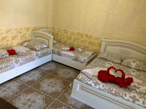 ロオにあるGuesthouse Korallの赤いバラが飾られた部屋のベッド2台