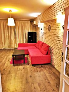ein Wohnzimmer mit einem roten Sofa und einer Ziegelwand in der Unterkunft Dream Residence nerva traian! in Bukarest
