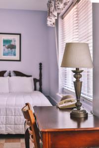 um quarto com uma mesa com um candeeiro e uma cama em The Lodge at Wakulla Springs em Crawfordville