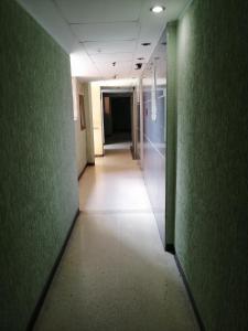 an empty hallway in an office building with green walls at Hotel El Limón in Caracas