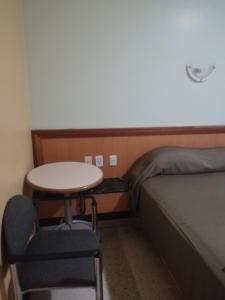 a small room with a bed and a table and chair at Hotel El Limón in Caracas