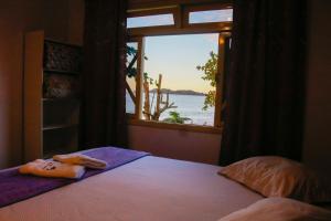 Dormitorio con ventana con vistas al agua en Pousada Encantos De Penha, en Penha