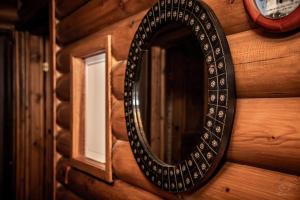 a mirror on the wall of a log cabin at *2 bdr log house /mountains/Queen bed/fireplace in Gourri