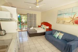 a living room with a couch and a bed at Tropical Palms Resort & 4WD Hire in Picnic Bay