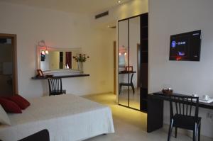 Olo Kalò Locanda في كوريليانو دوترانتو: غرفة نوم بها سرير ومكتب ومرآة