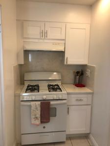 a white kitchen with a stove and white cabinets at 3 Bedrooms Guest House, Pacific Beach, Sea World, Downtown,& 3 bus lines-3 in San Diego