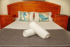 a bed with two rolls of toilet paper on it at Tropical Palms Resort & 4WD Hire in Picnic Bay +27 photos