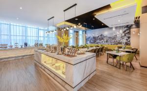 a restaurant with tables and chairs in a room at Atour Hotel (Tianshui Hige Speed Railway South Xihuang Avenue) in Tianshui