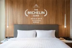 台北的住宿－Home Hotel，一张配有白色床单的床。